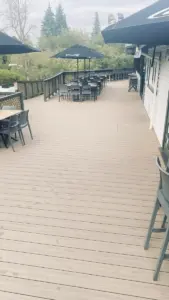Decking outside Tea Kiosk cafe with umbrellas and chairs